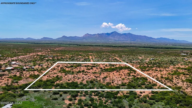 Aerial view of one Paloma Trail lot outlined in white over desert scrub, approximate boundaries only, with mountains on the horizon