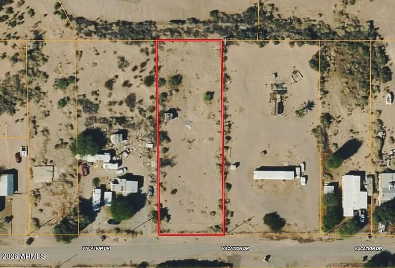 Closer aerial view of the lot outlined in red with neighboring homes and yards on the surrounding streets