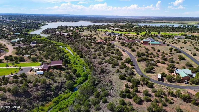 Aerial view of the Eagle Crest neighborhood with homes, paved streets and White Mountain Lake beyond