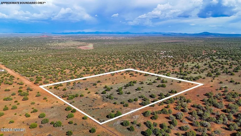 Aerial view of the 10-acre parcel outlined in white over juniper flats, approximate boundaries only, with a dirt road at the edge