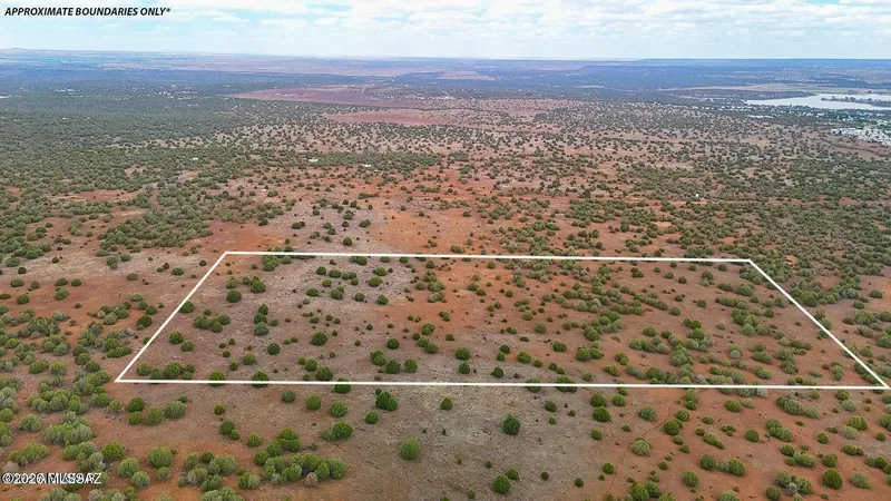 Aerial view of the 20-acre parcel outlined in white over juniper flats, approximate boundaries only, with the lake at the top right