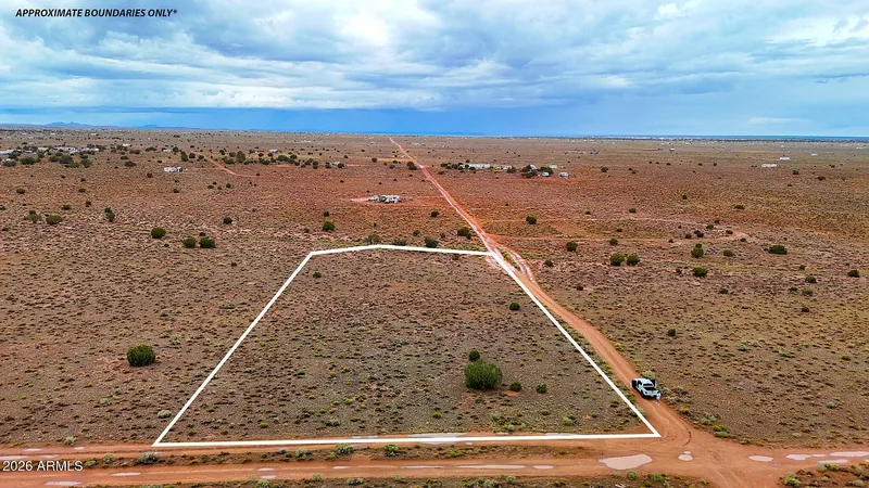 Aerial view of a lot outlined in white beside Avondale Road, approximate boundaries only, with open grassland and a truck on the road