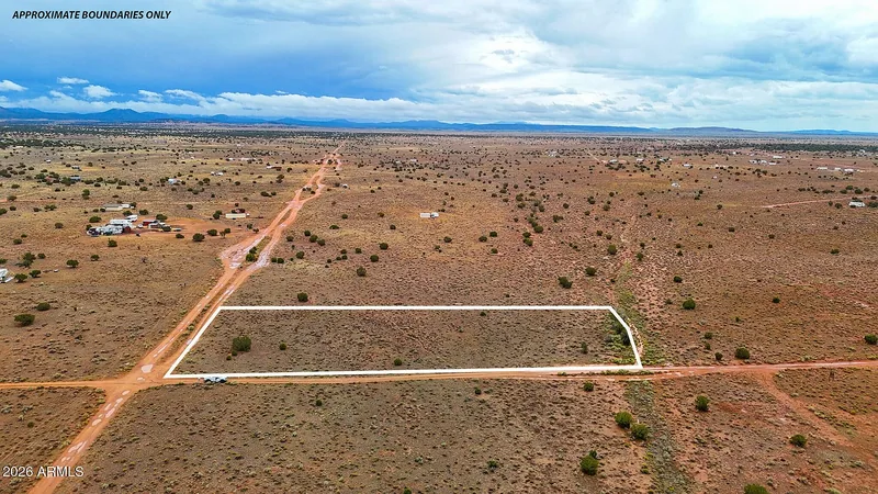 Aerial view of a second lot outlined in white along the road, approximate boundaries only, with scattered homes on the plateau